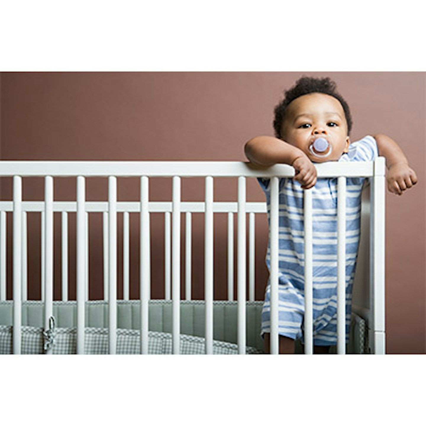 baby in cot with dummy