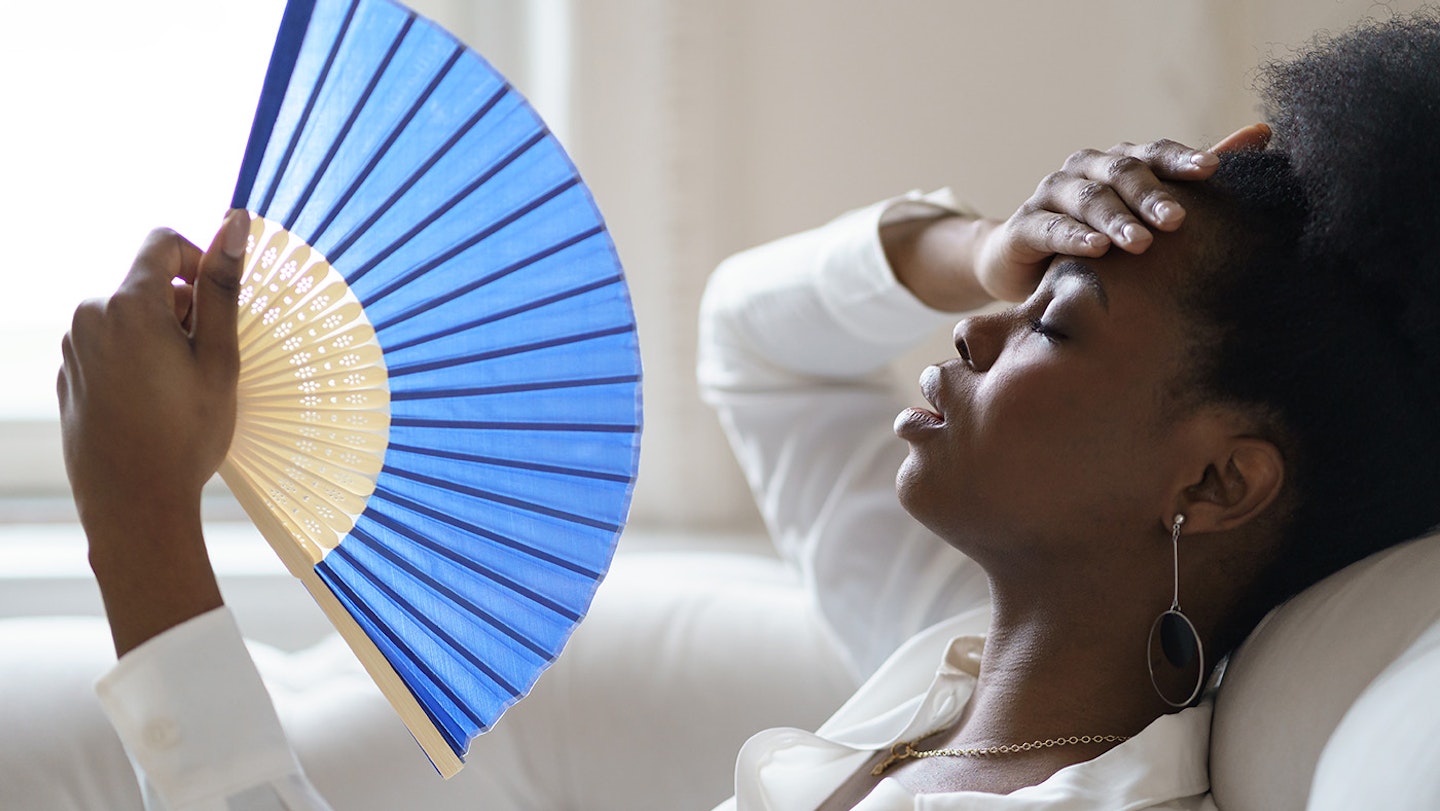 young woman with menopause fanning herself