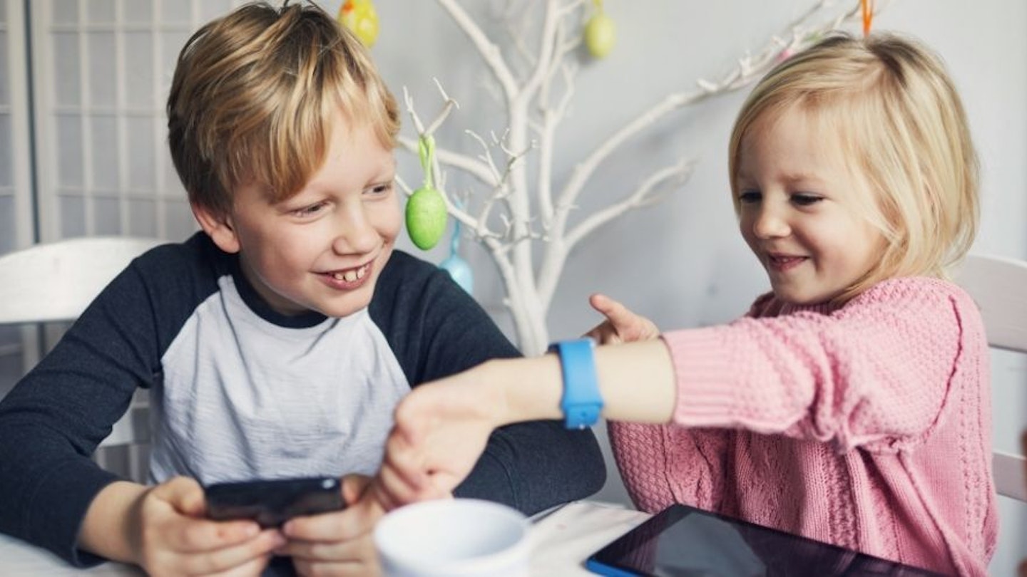 Two children looking a children's smartwatch on a child's wrist