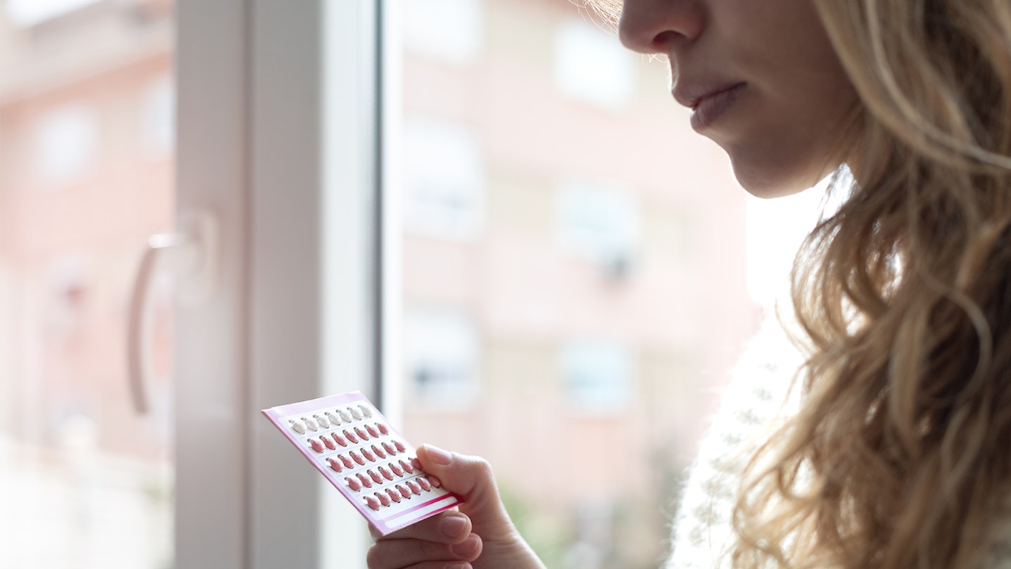 woman looking at pill packet