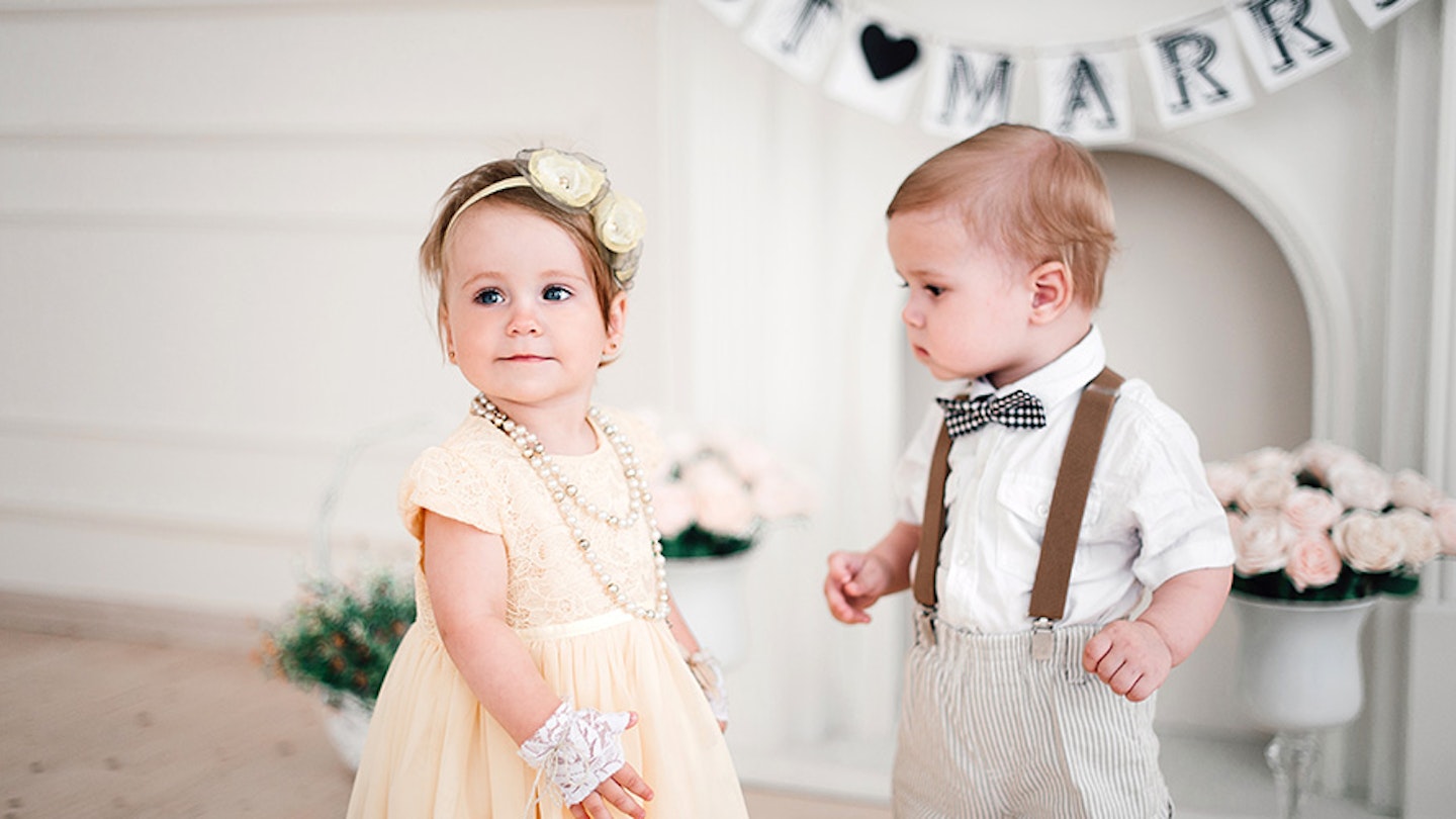 Two babies at a wedding wearing baby wedding outfits