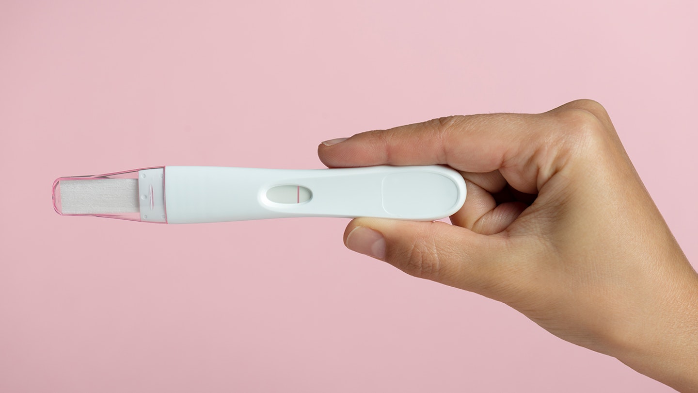 woman holding a negative pregnancy test