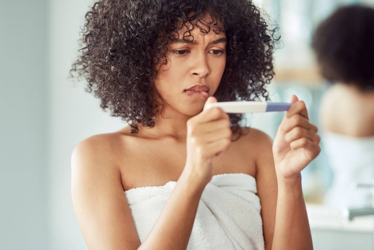 woman looking confused at pregnancy test