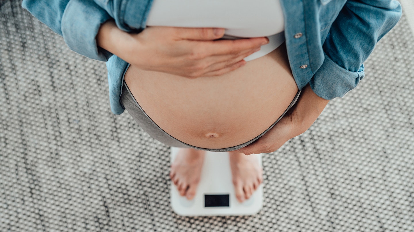 pregnant woman weighing self