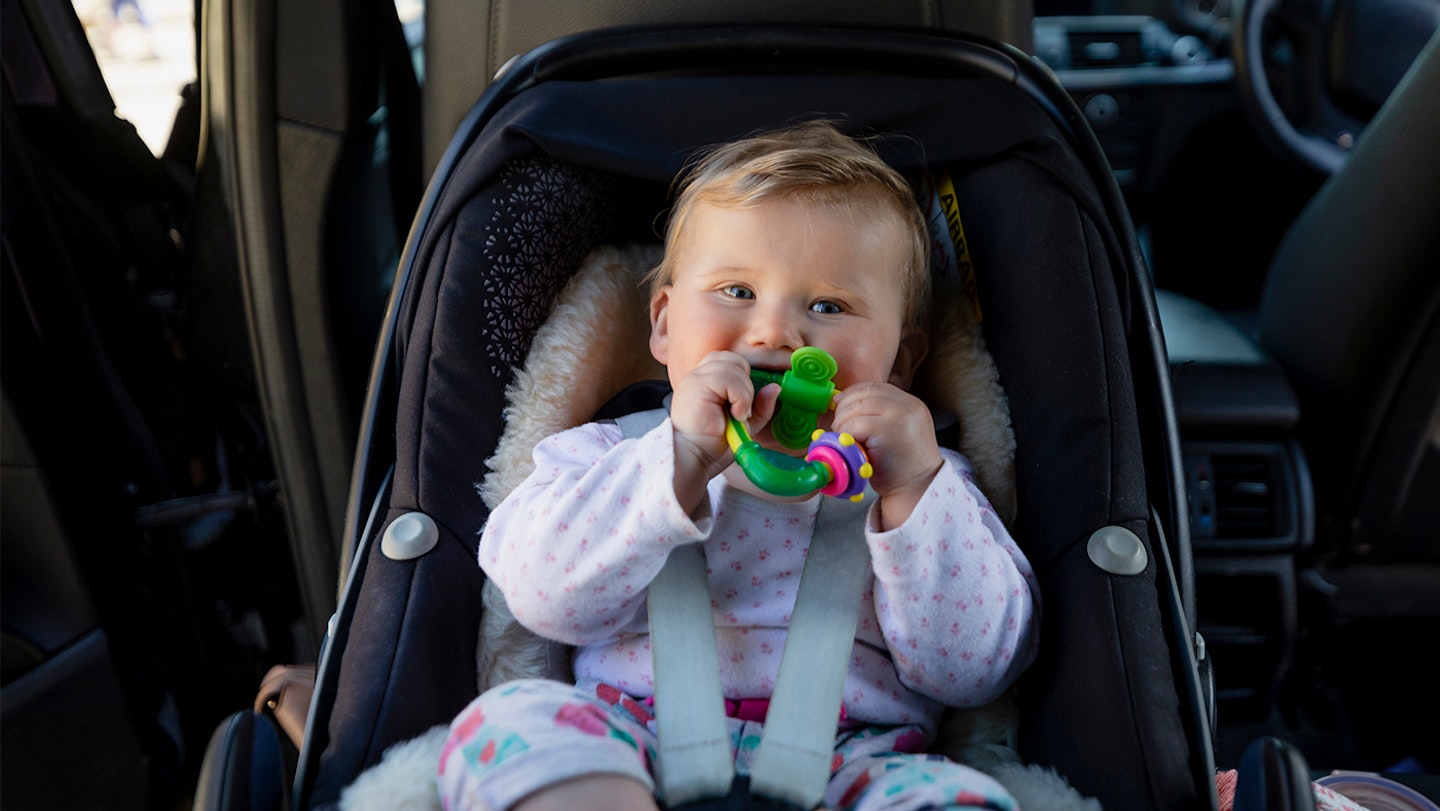 baby in car seat with toy