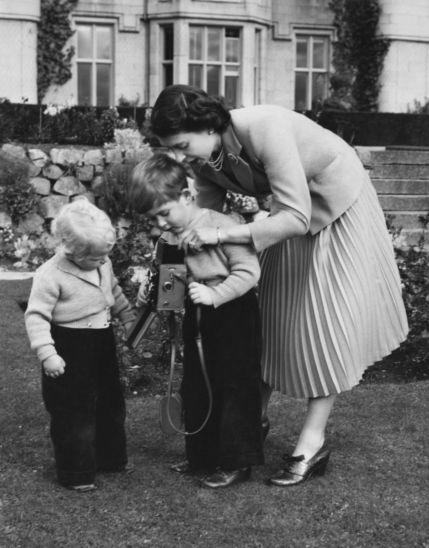 Queen Elizabeth II helps her son Prince Charles to take a picture 