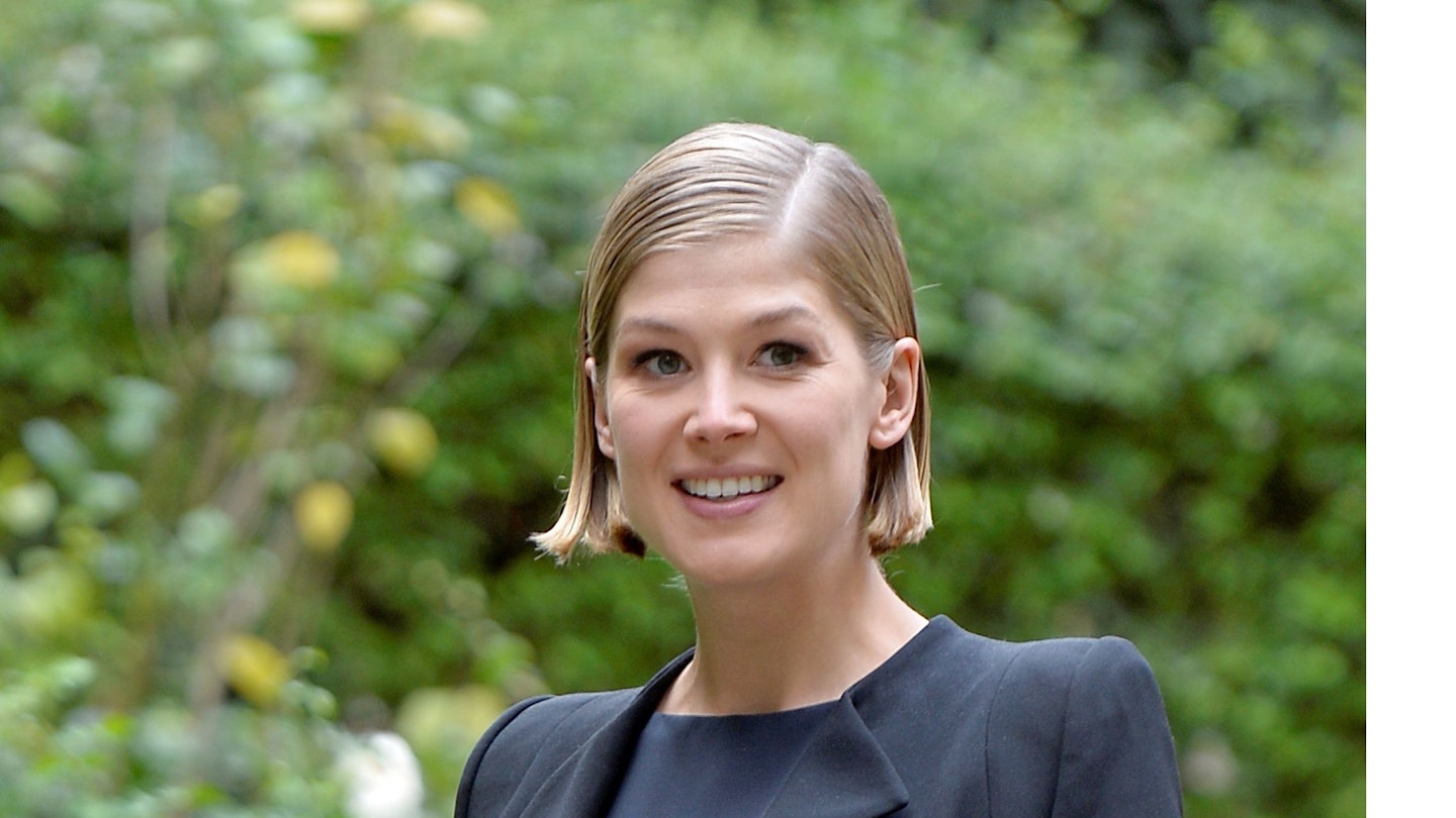 Rosamund dressed her neat baby bump in an elegant loose-fitting navy dress and matching jacket at the <em>Gone Girl</em> photocall in Rome.