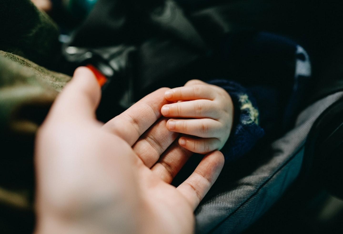 baby and parent holding hands