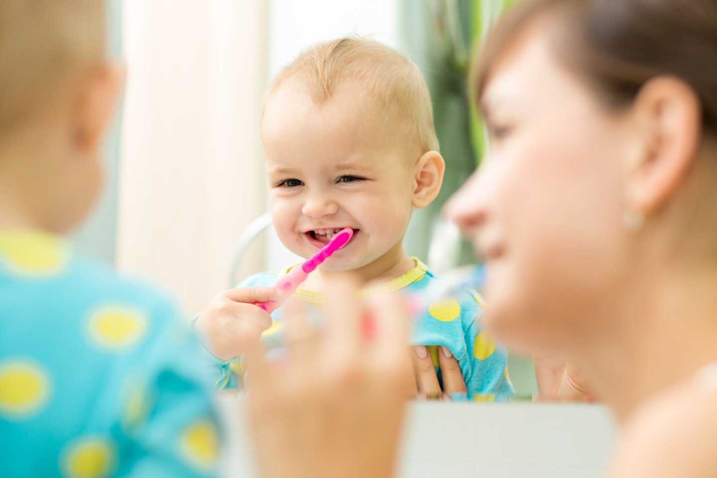 Mum and toddler brushing their teeth together
