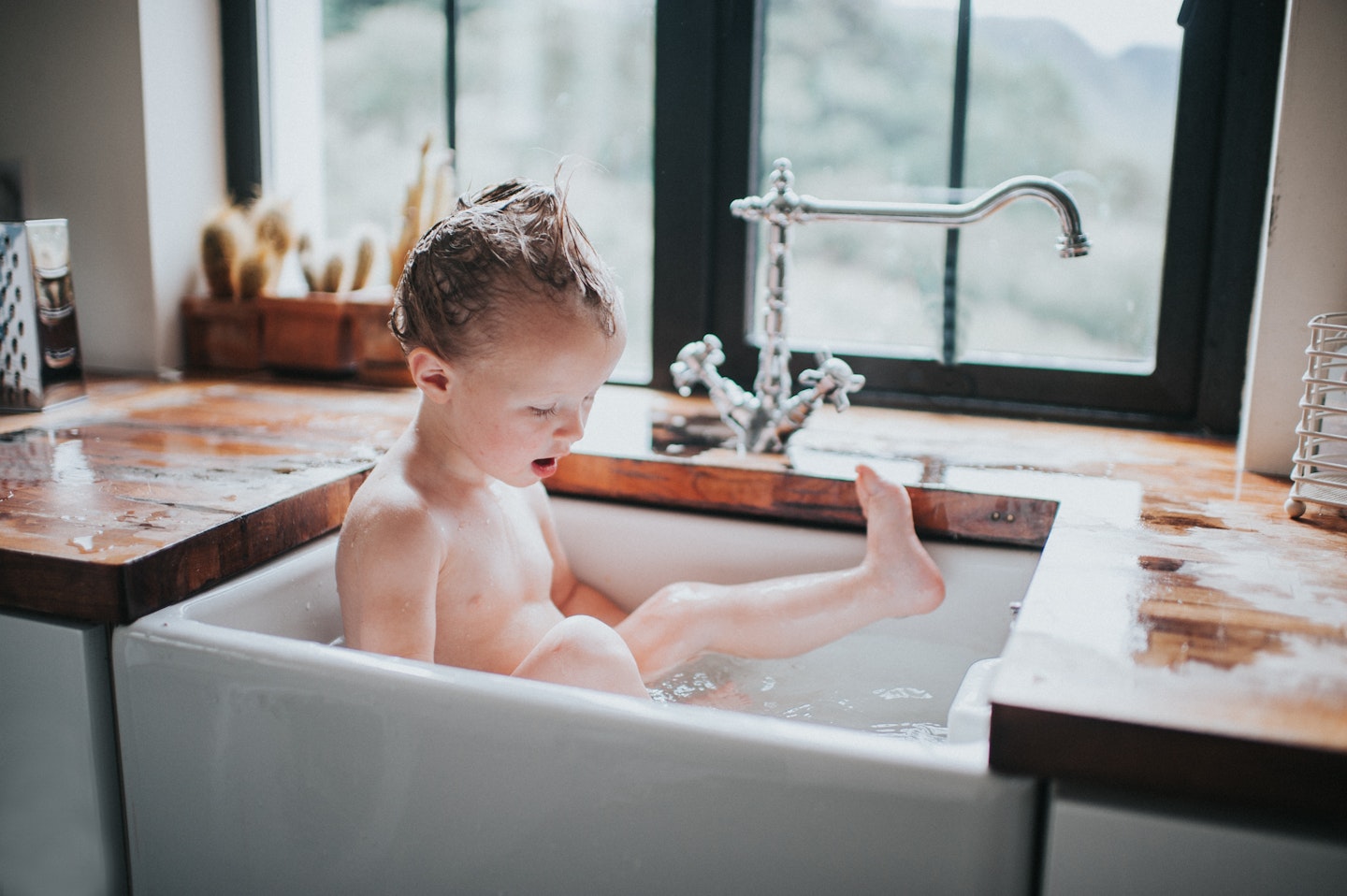 baby bathing in the kitchen sink