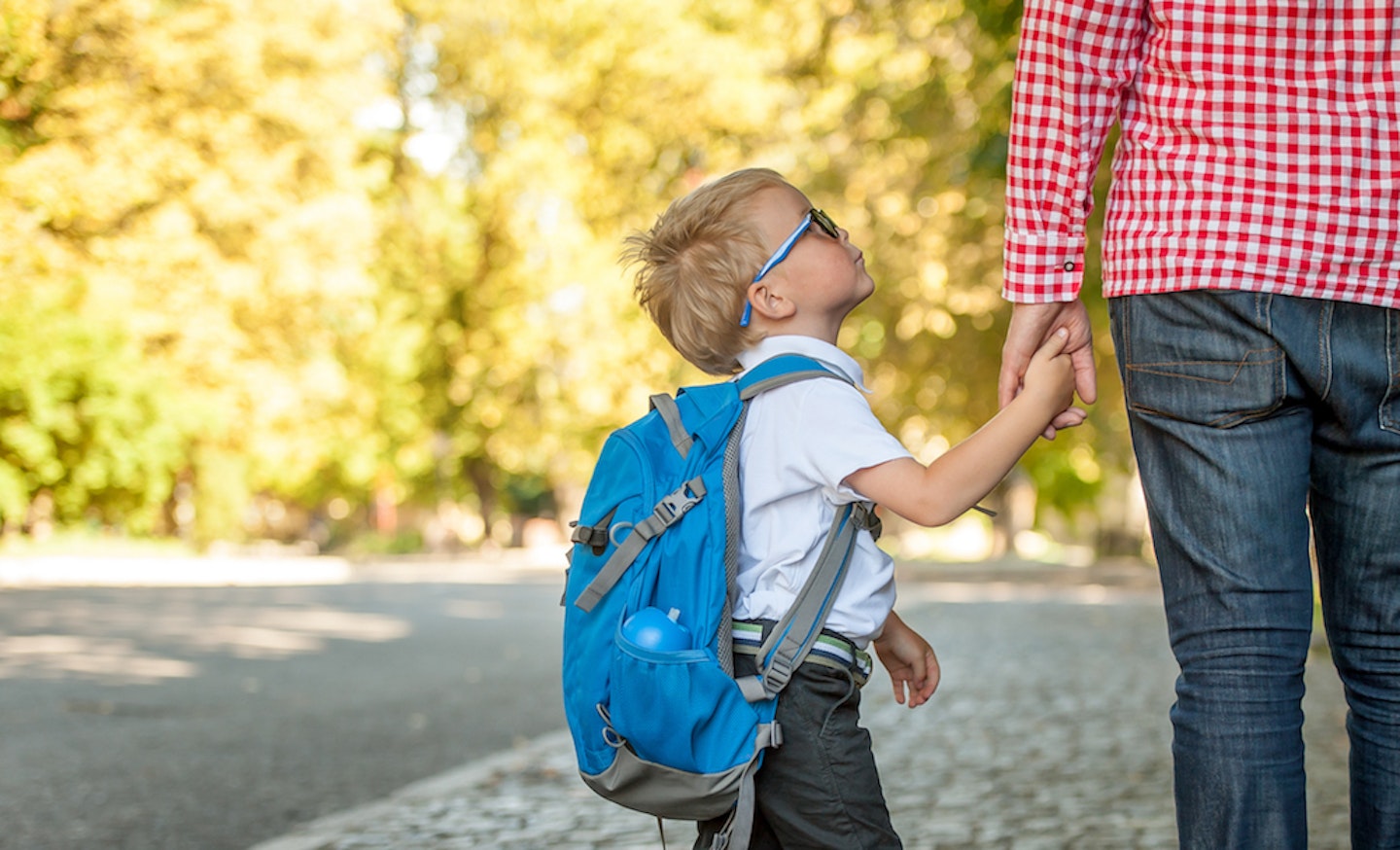 child holding parent's hand on school run