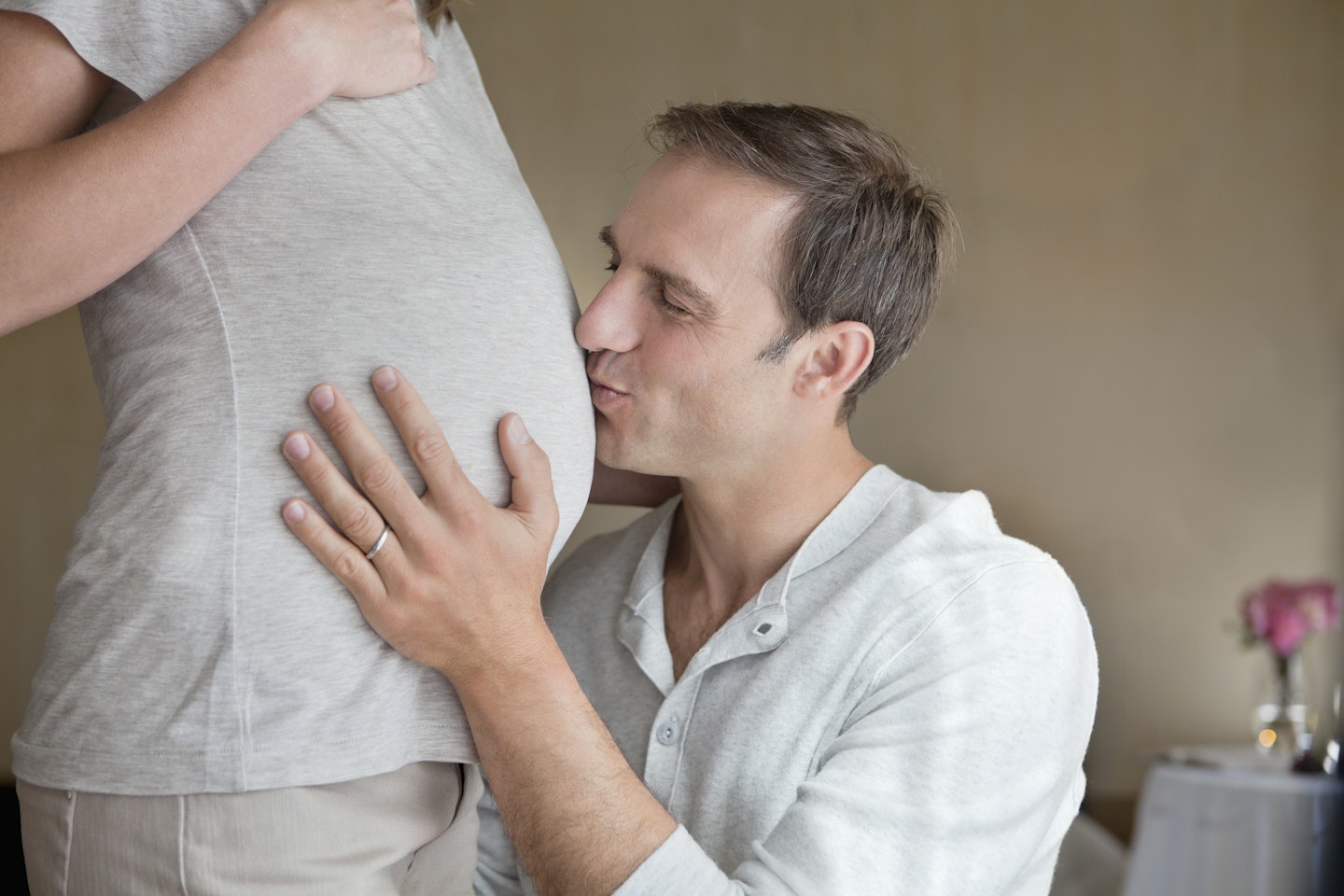 Man kissing baby bump