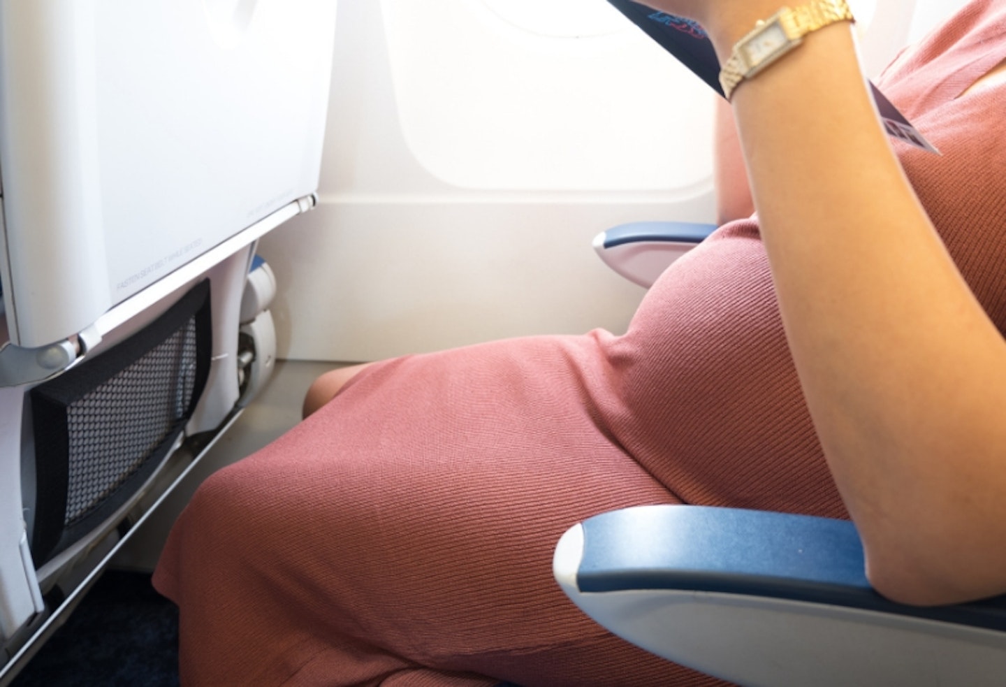 Side image of a pregnant woman on a plane