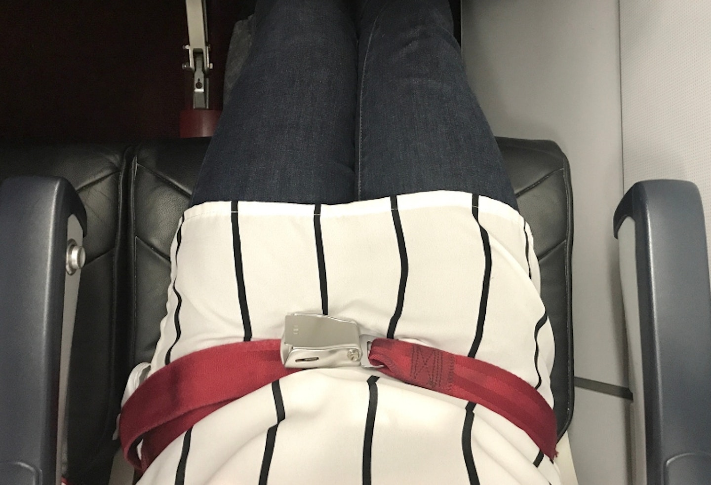 Top down image of a pregnant woman on a plane