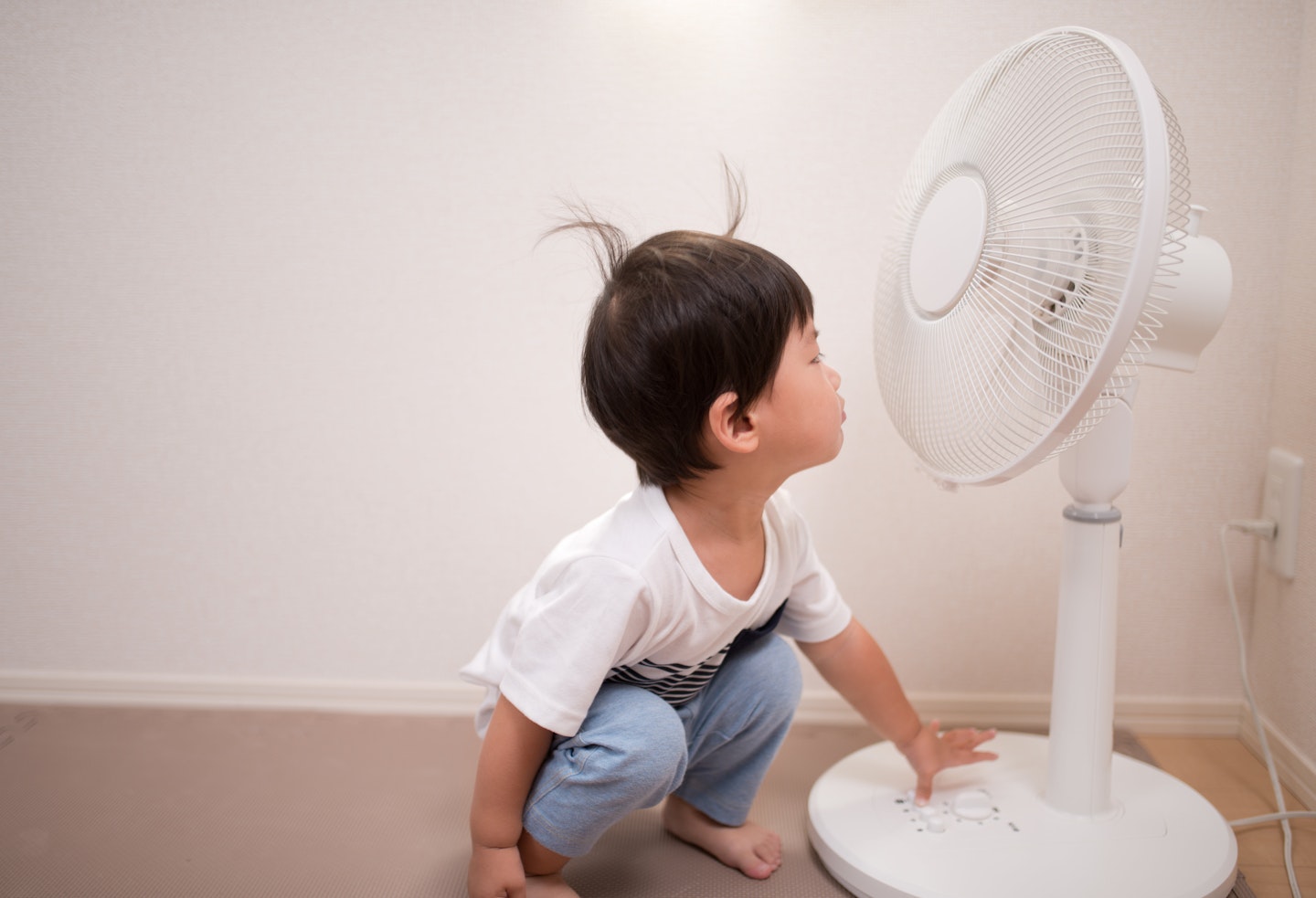 Toddler with fan cooling down