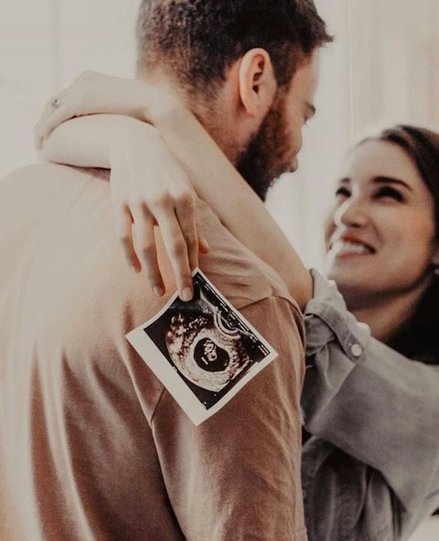 couple holding pregnancy scan