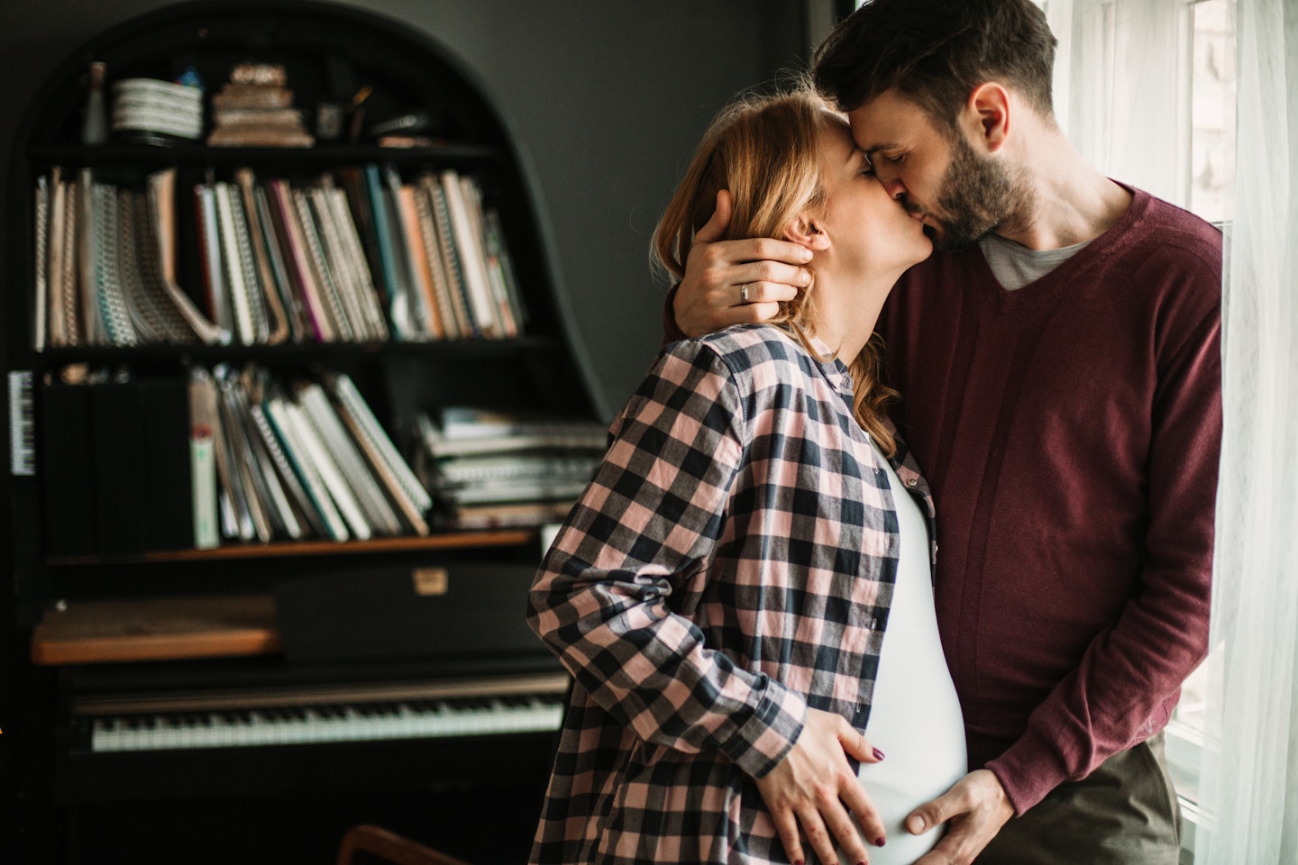 pregnant woman and partner kissing