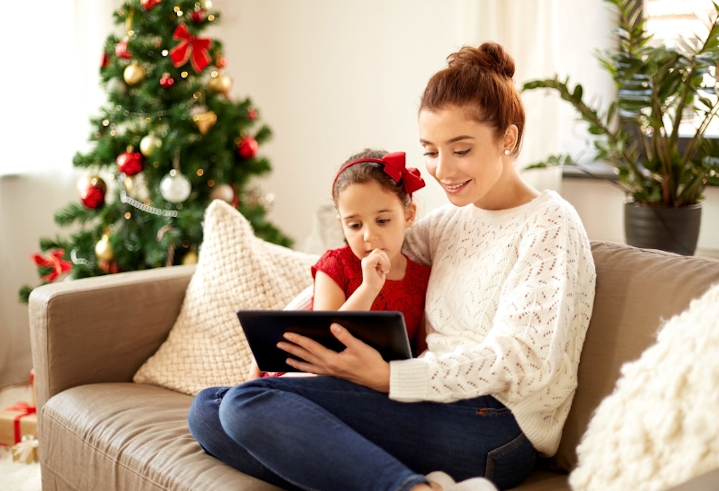 Mother reading or on tablet with daughter at Christmas time
