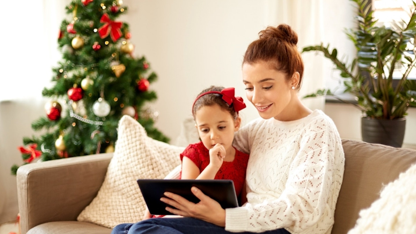 Mother reading or on tablet with daughter at Christmas time