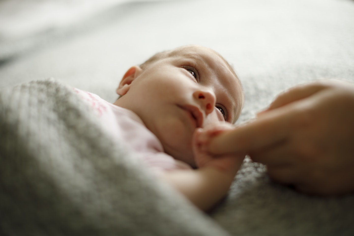 newborn baby holding mum's finger