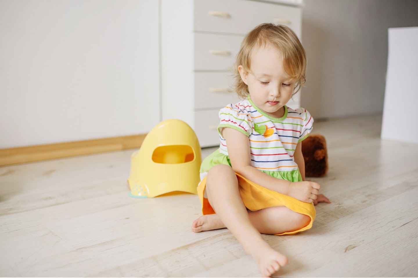 Toddler sitting next to the potty