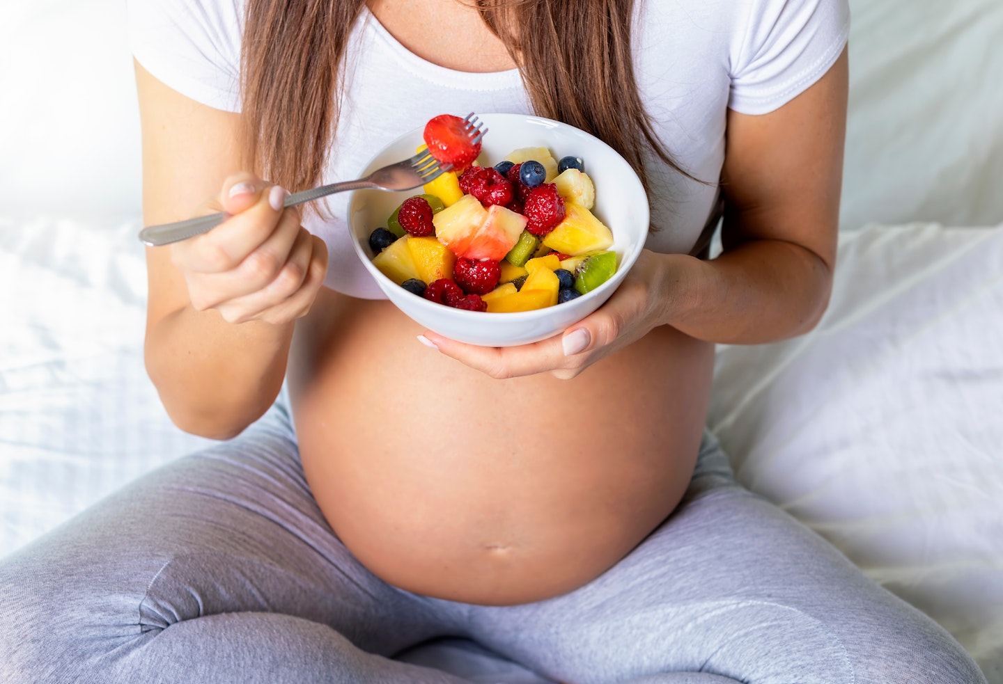 Pregnant woman eating fruit 