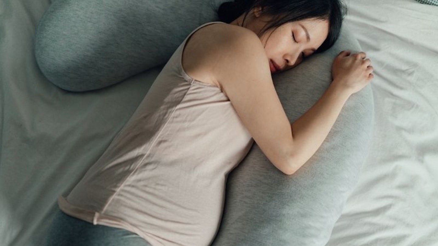 woman hugging pregnancy pillow