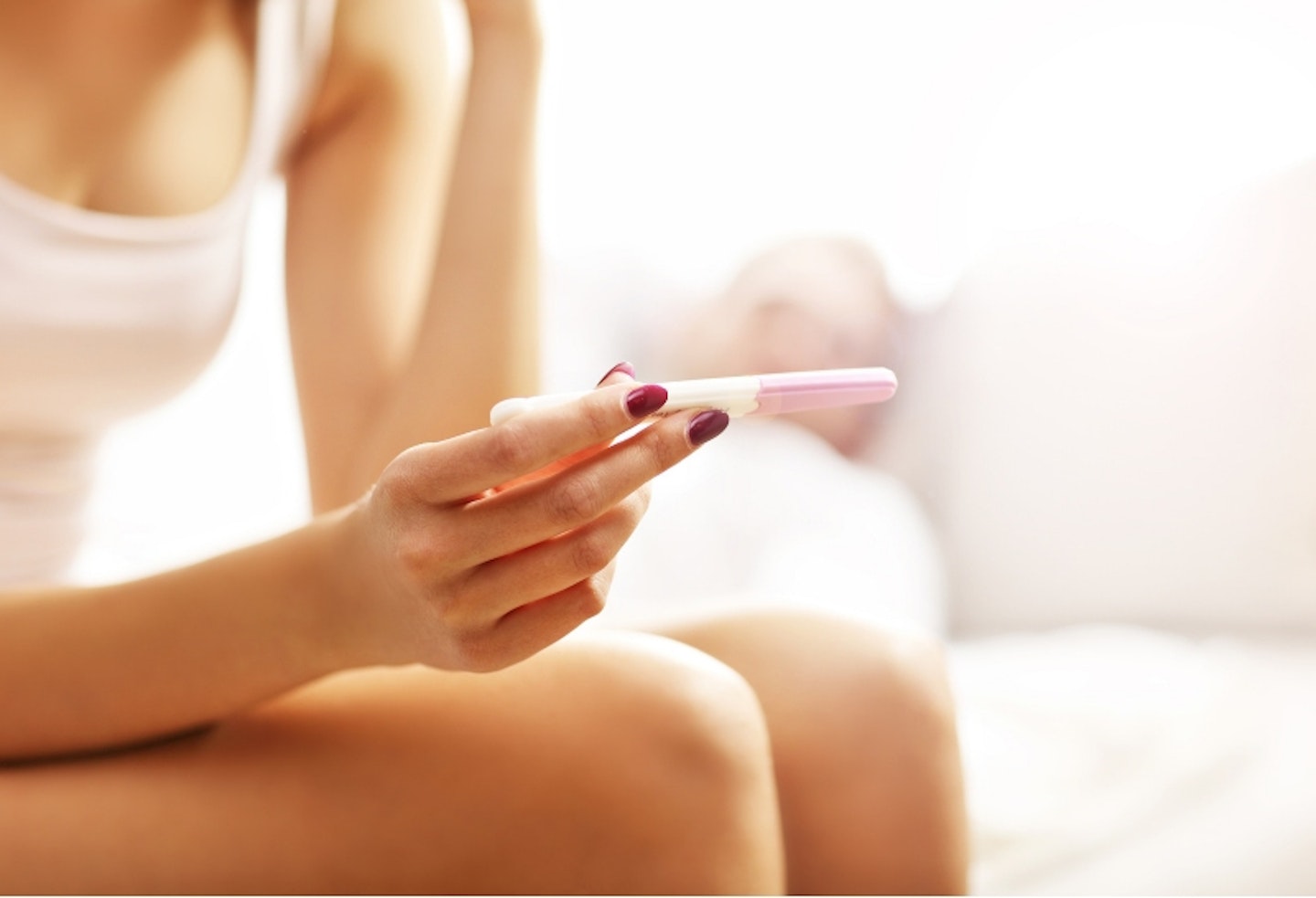 woman checks pregnancy test to see result