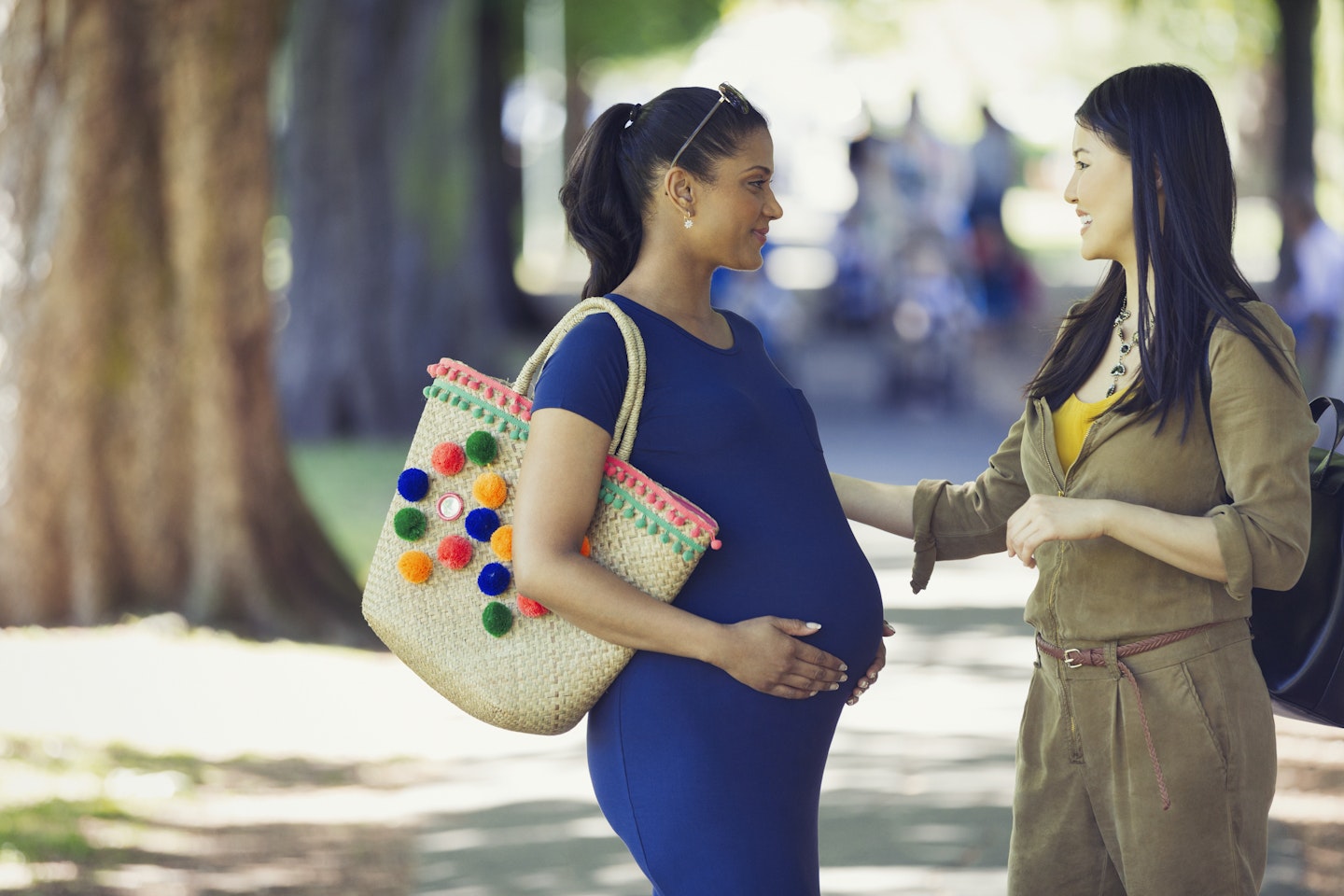 Pregnant woman talking to a friend outside