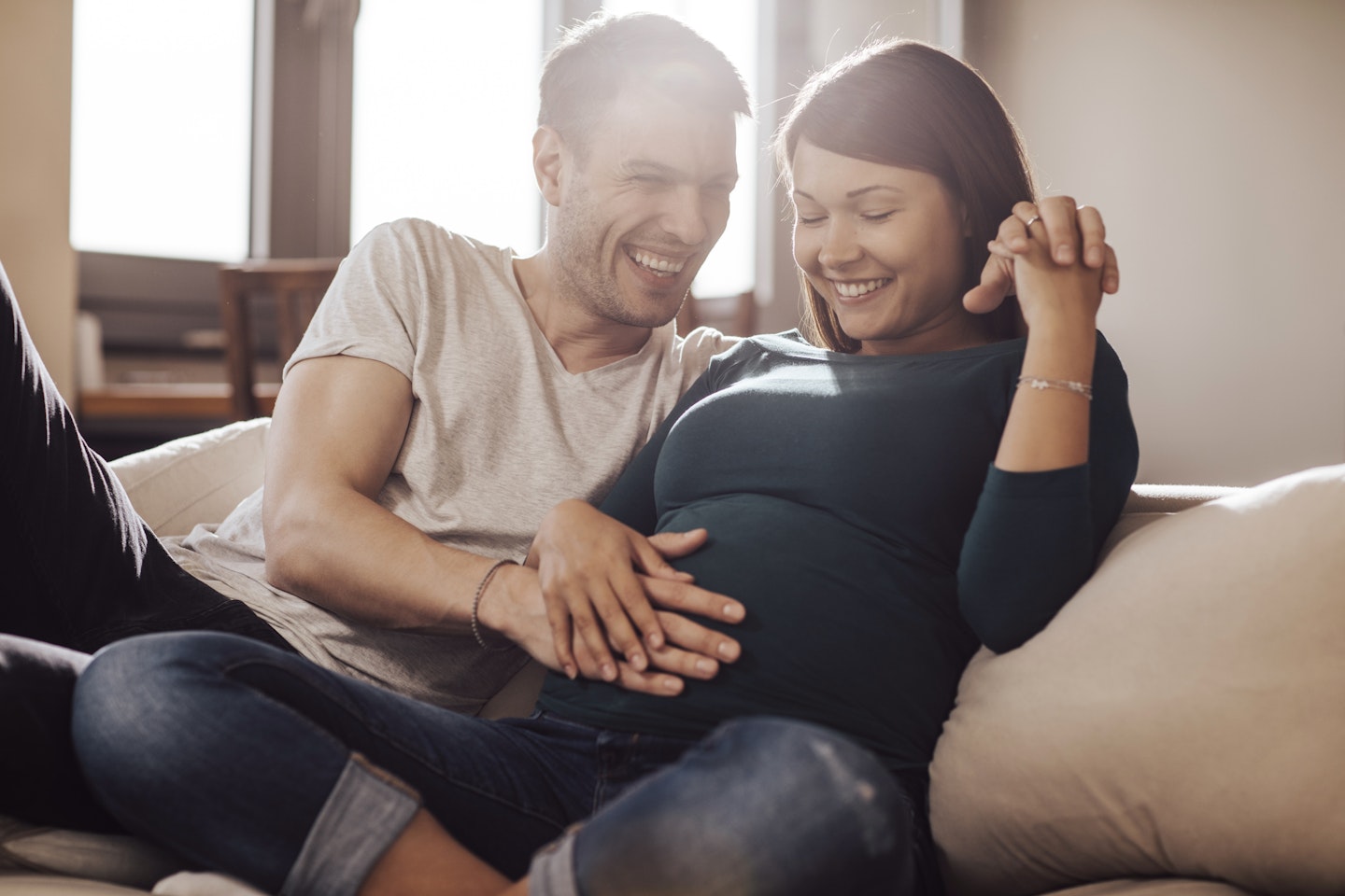 Pregnant woman and partner feeling her bump