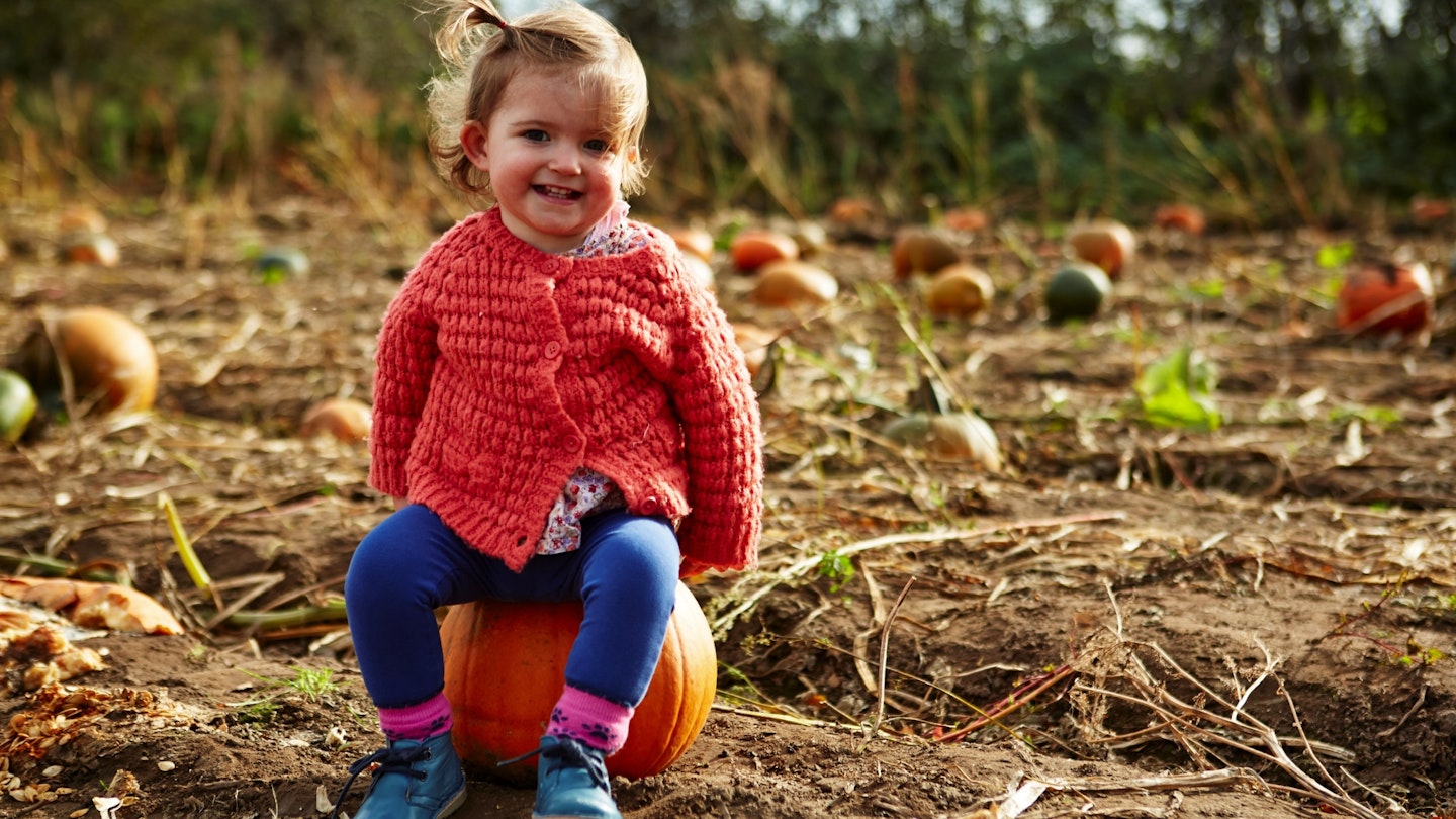 Child sitting on a pumpkin
