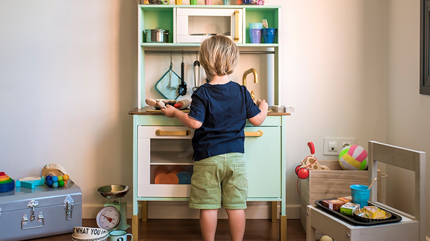 Toddler cleaning their play kitchen