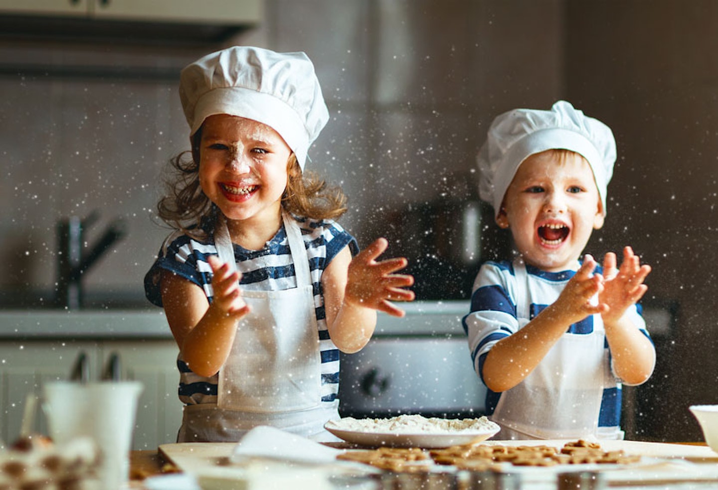Children learning baking hats, baking and laughing with flour in the air