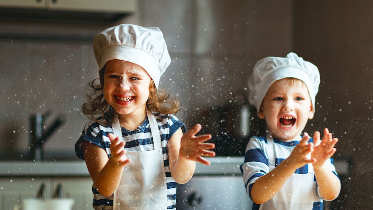 Children learning baking hats, baking and laughing with flour in the air