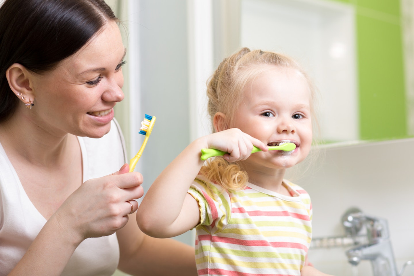 mum and toddler brushing their teeth together