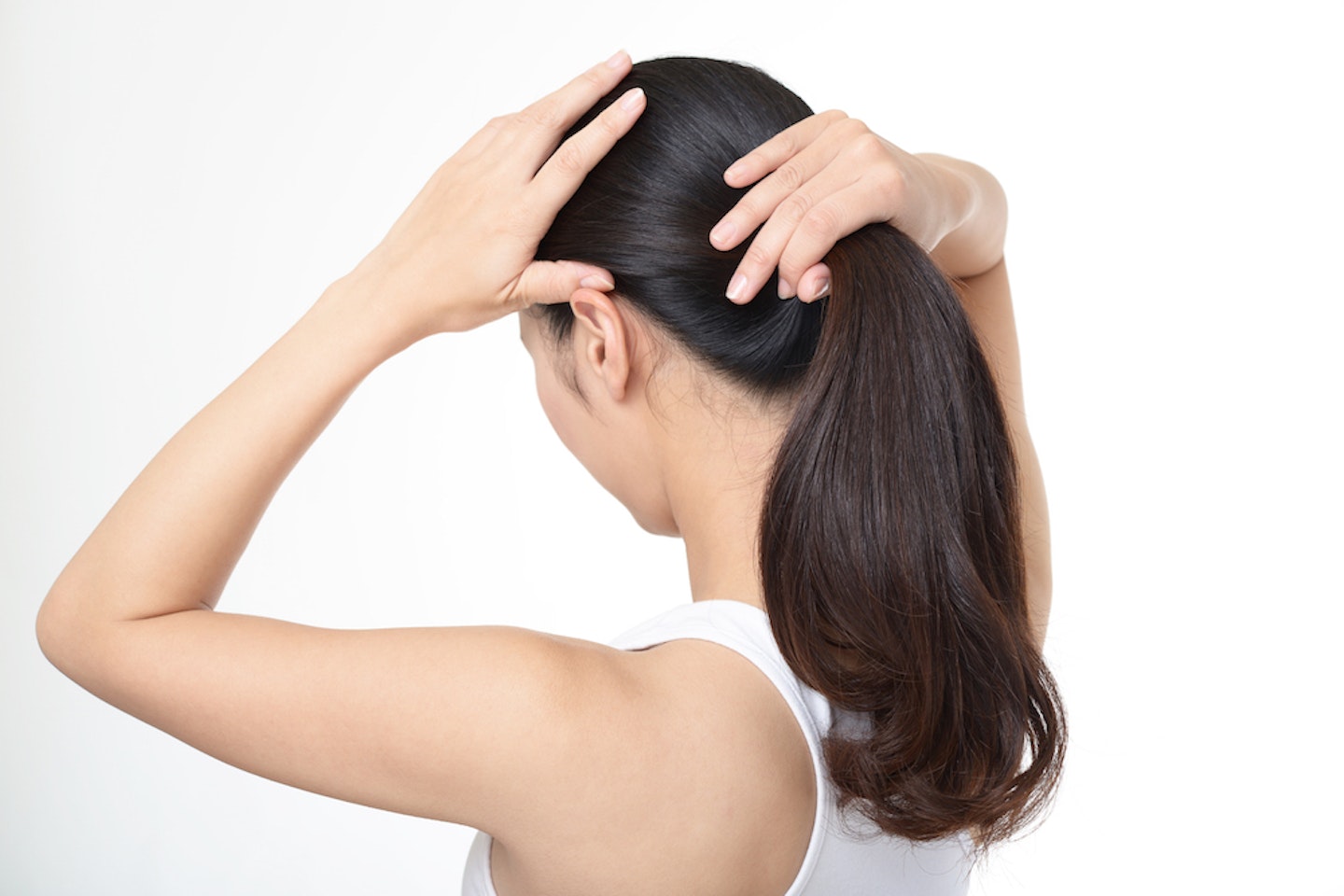 woman putting hair in ponytail 