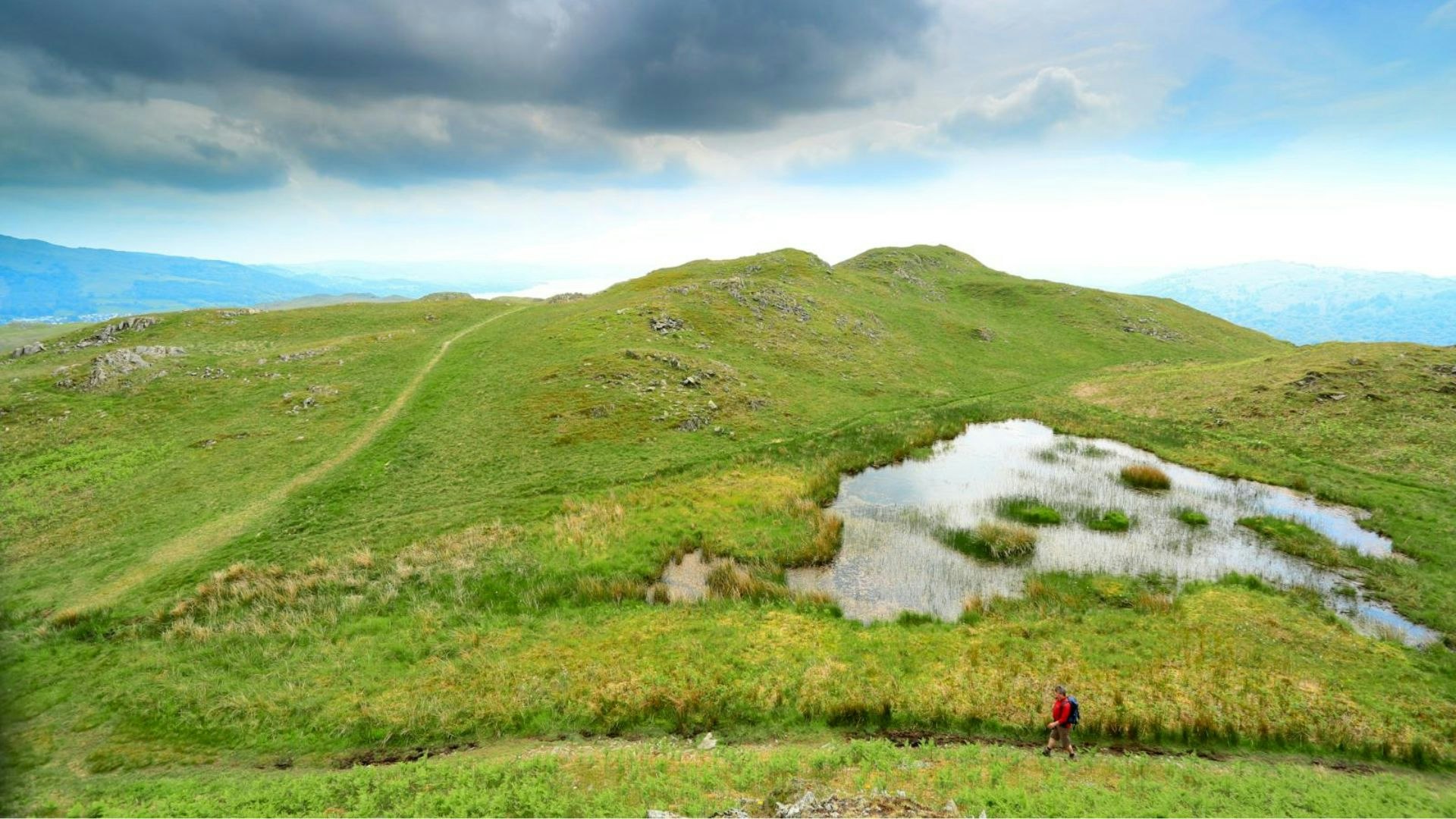 Walker near the summit of Loughrigg, Lake District