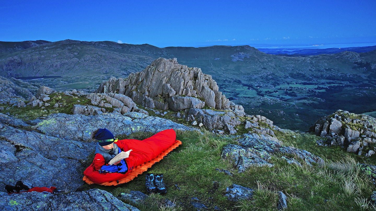 Hiker using a bivvy in Harter Fell Summit Lake District