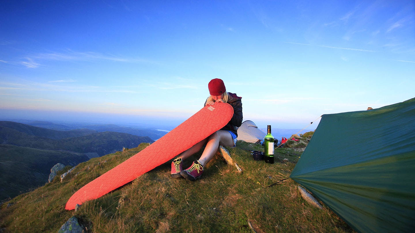 Hiker inflating a sleeping mat