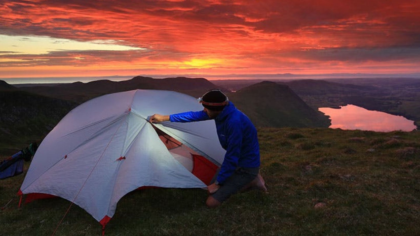 camping at sunset using a headtorch