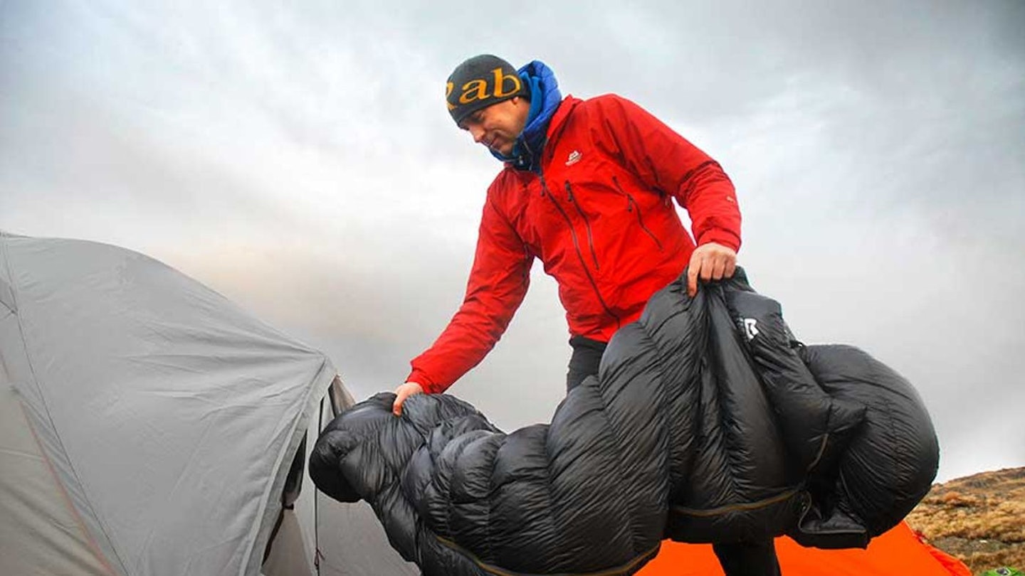 Hiker inserting sleeping bag into tent