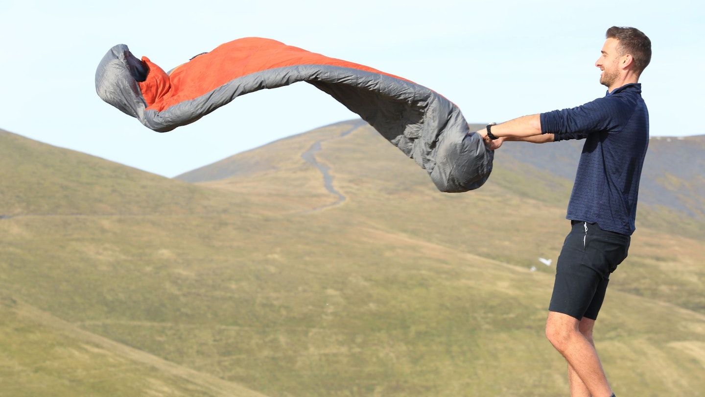 Shaking out a sleeping bag after breaking camp