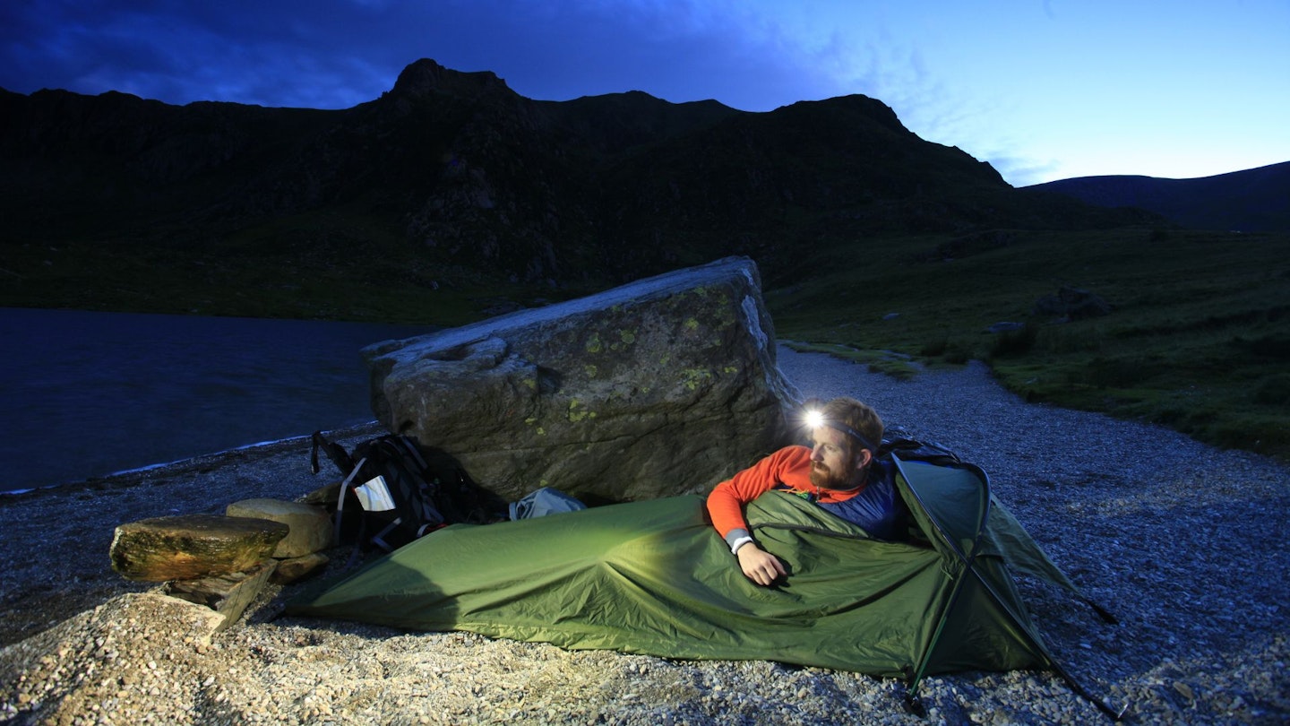 Hiker using a bivvy bag, Lynn Idwal, Snowdonia