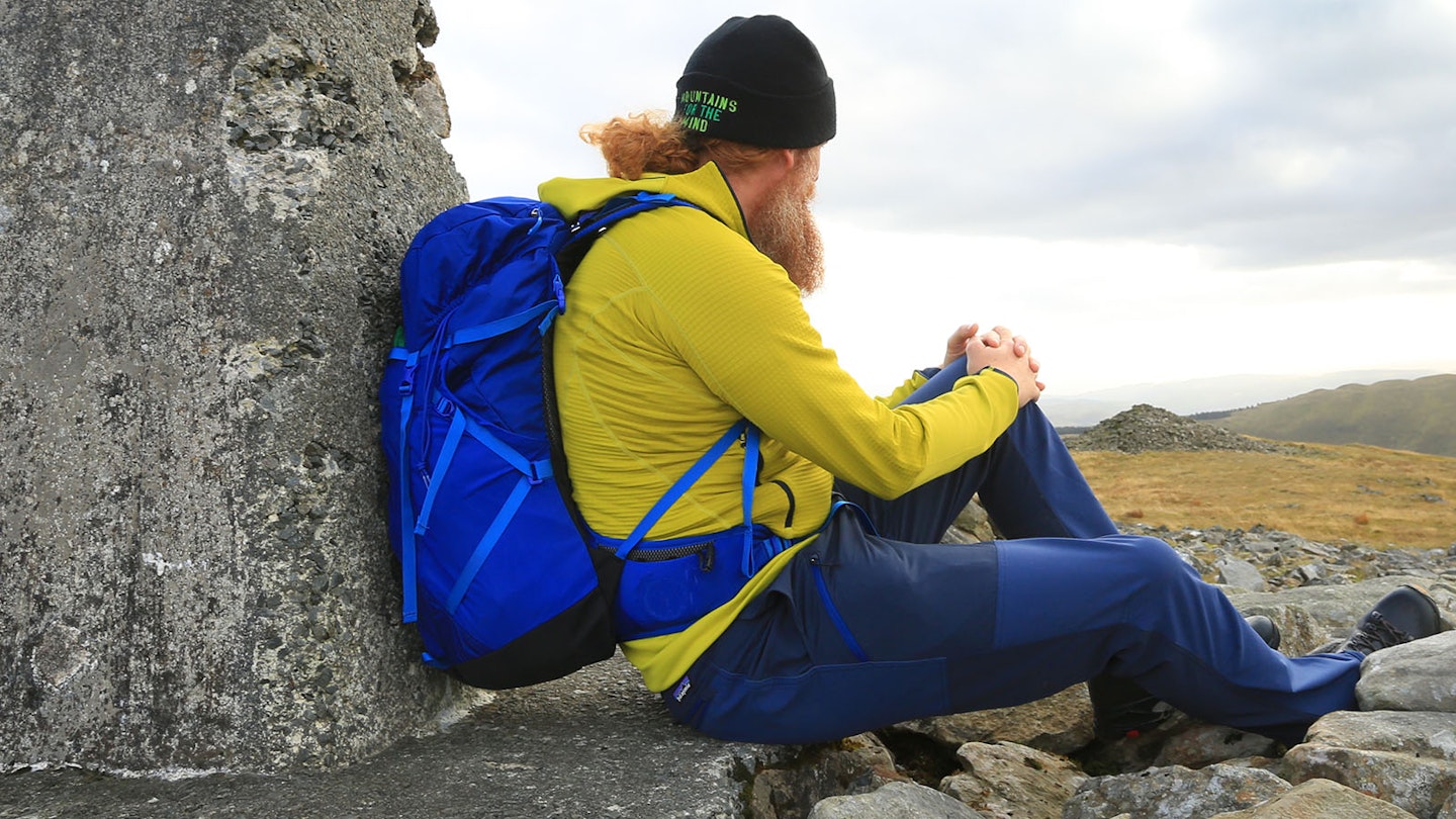 Hiker on a summit with Osprey Sportlite 30 rucksack