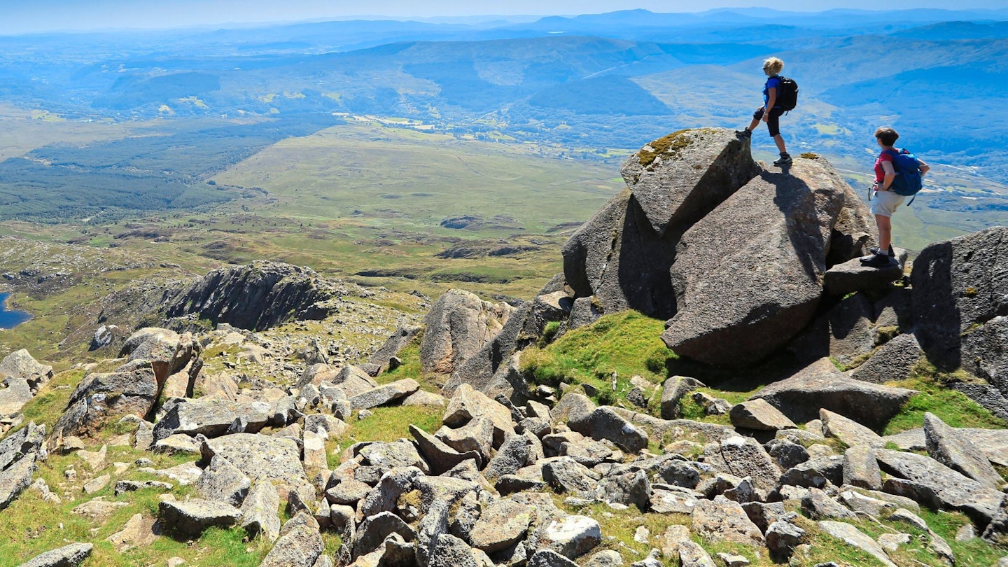 Two hikers wearing daypacks in summer