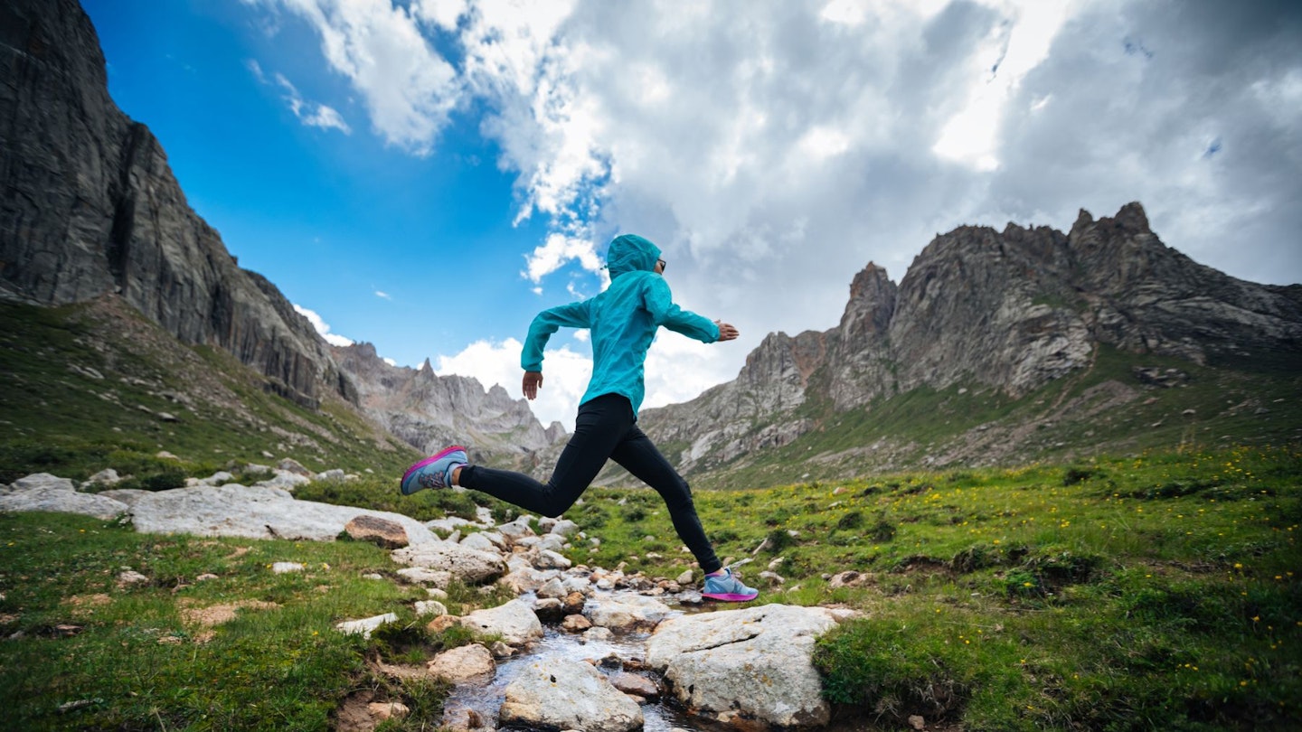 Woman trail running in hills