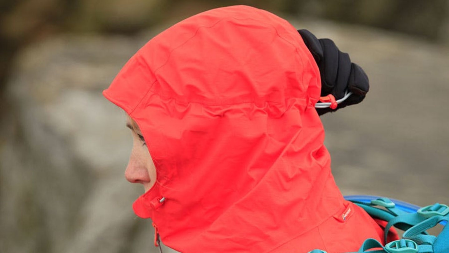 Hiker adjusting the hood on a waterproof walking jacket