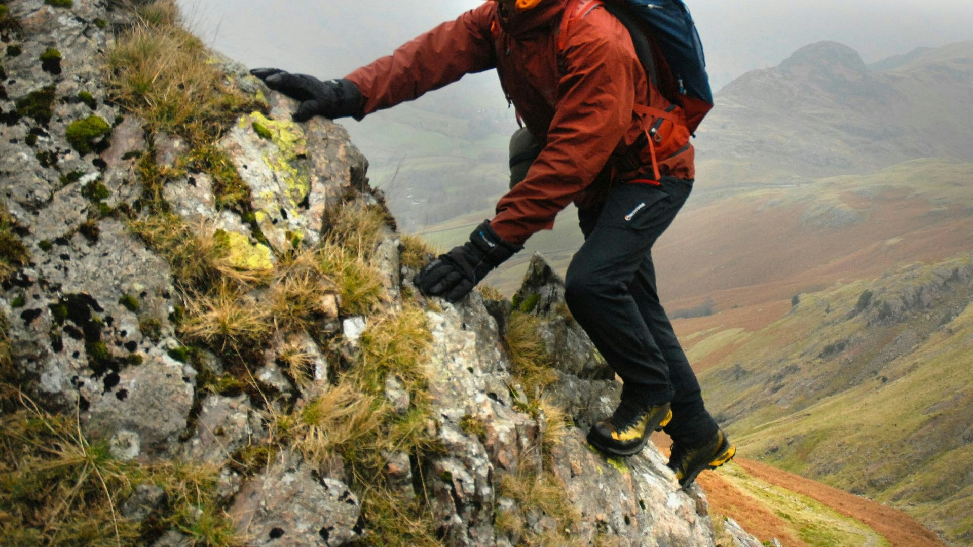 Hiker scrambling wearing waterproof gloves