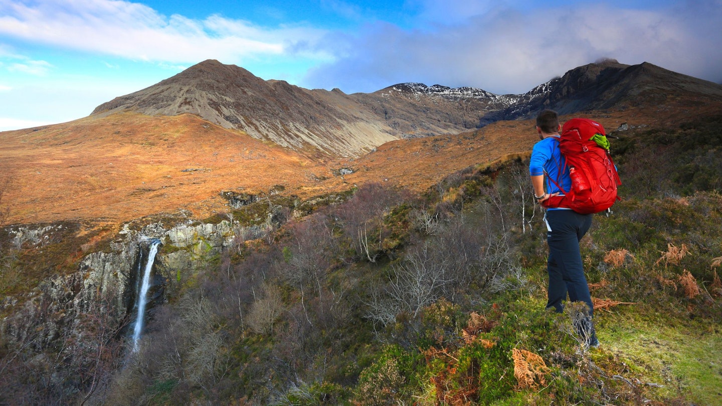 Hiker looking a Eas Mor Waterfall, Isle of Skye