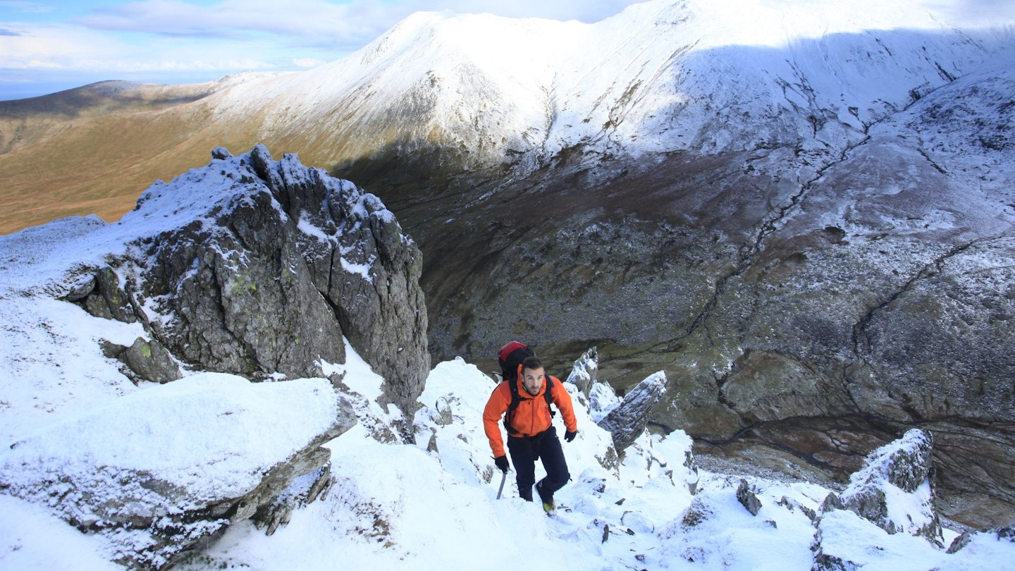 Hiker midway up The Grib Lem Spur, Snowdonia in winter
